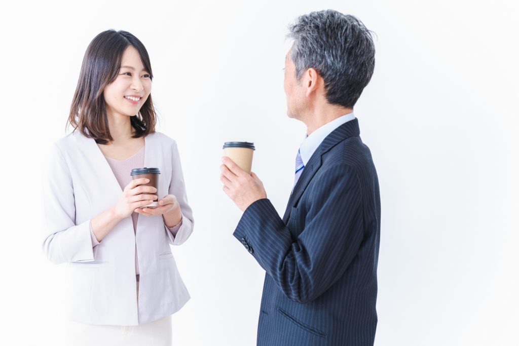 コーヒーを飲みながら話す会社員